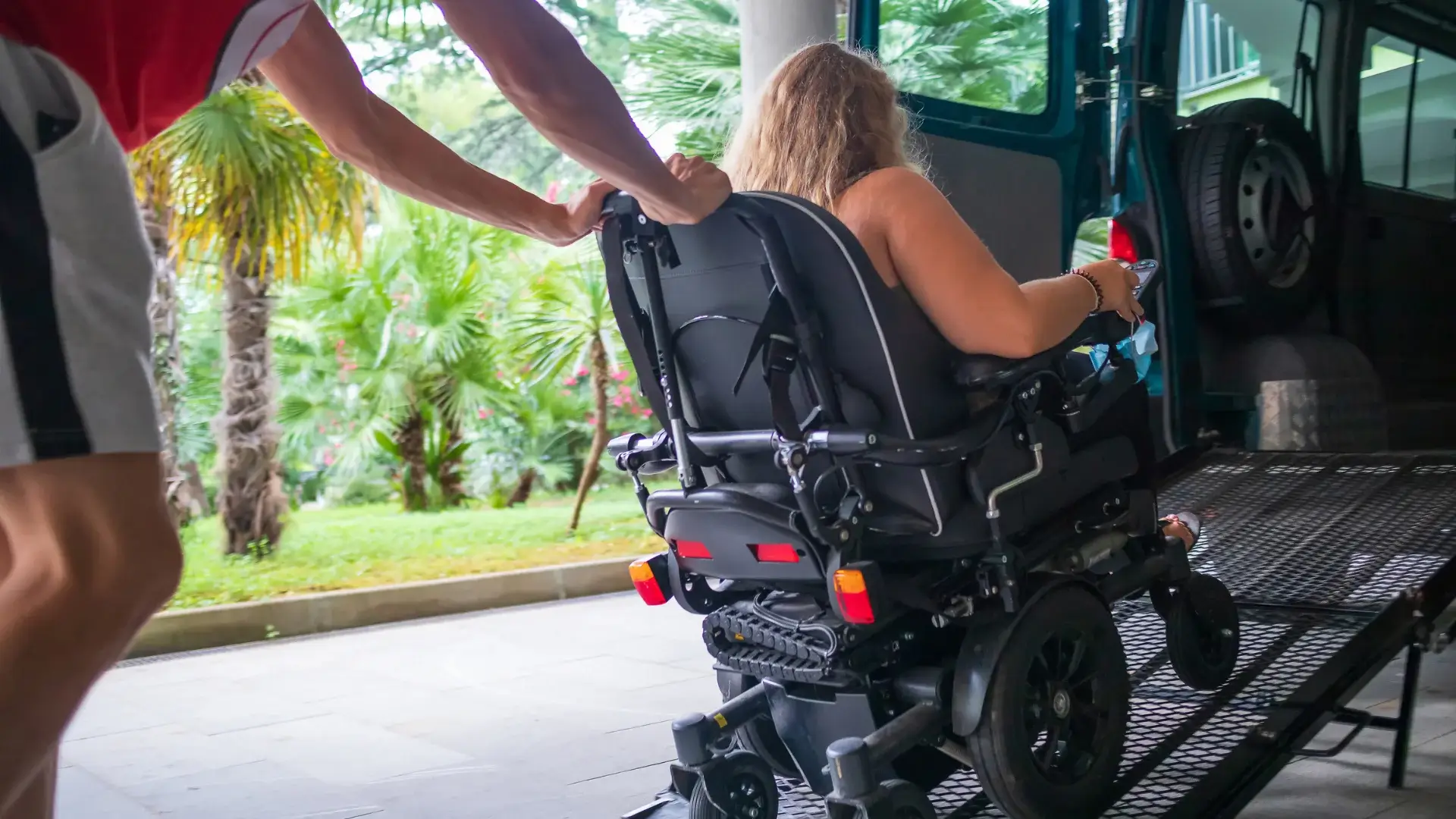 disabled person being assisted to get in to a vehicle